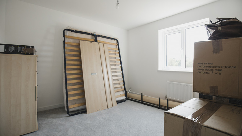 A bed frame leaned up against a wall in a bedroom