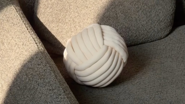 Knotted ball throw pillow on a couch