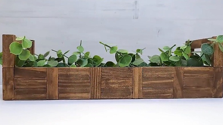 The completed planter box with some faux greenery in it
