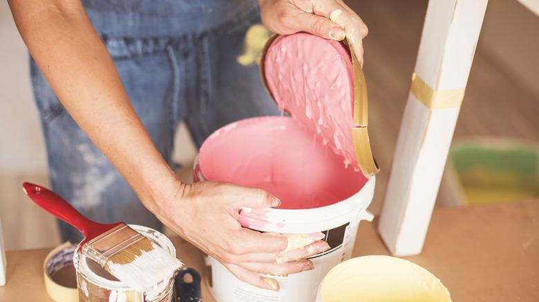 woman opening pink paint can
