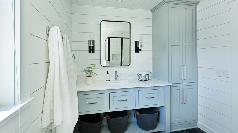 vertical storage cabinet beside vanity in bathroom