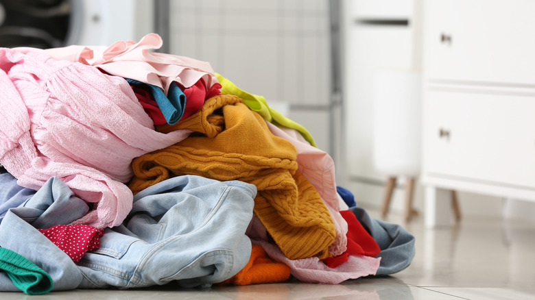 Dirty clothes piled on the floor.