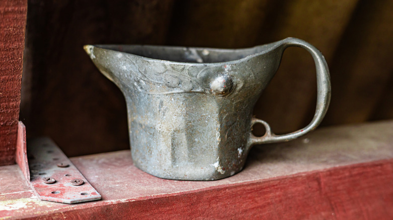 A vintage coal scuttle resting on wood