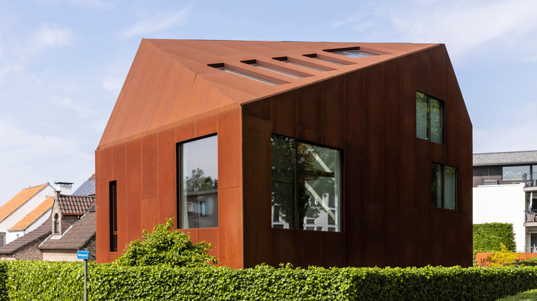 A home with corten steel cladding that has mellowed to a rich, dark red brown.