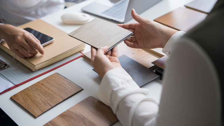 A person examines different wood finish samples.