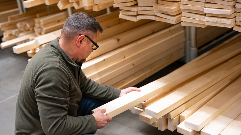 A man looking at timber ready for construction projects