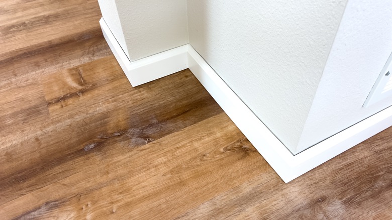 A hardwood floor surrounded by white trim