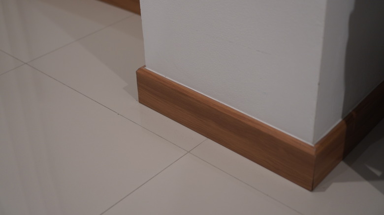 Wood trim displayed on the bottom of a white wall