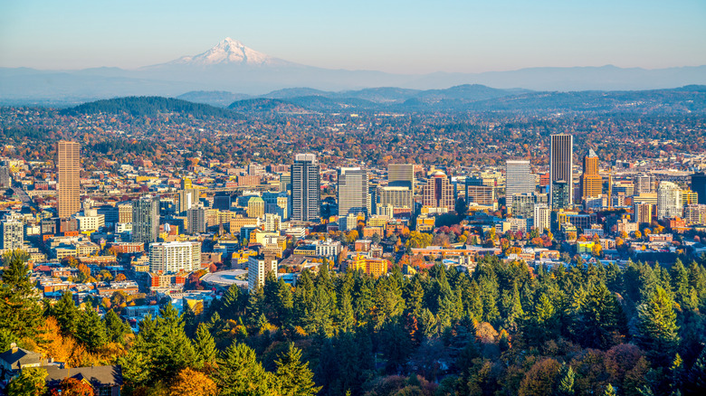 Skyline of Portland, Oregon and Mount Hood, the city framed by green trees shifting into autumn oranges