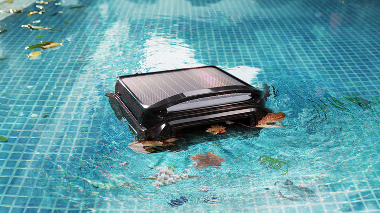 A WYBOT F1 skimming a pool with leaves in the water