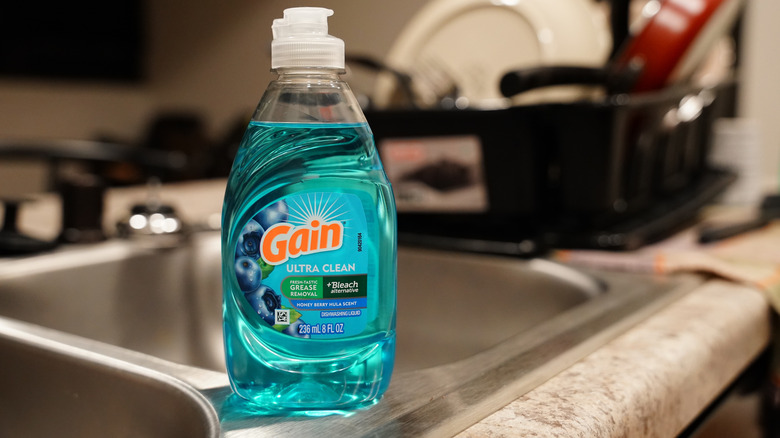 A bottle of dish soap sitting on a kitchen countertop