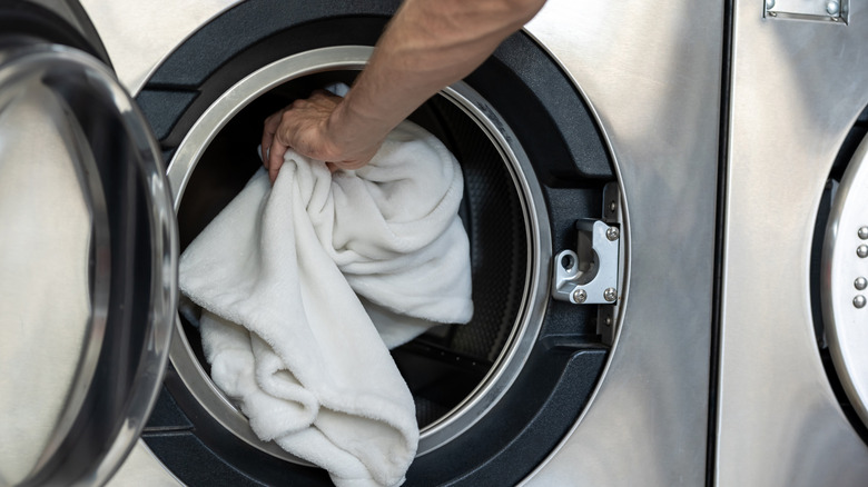 hand putting clothes in washer