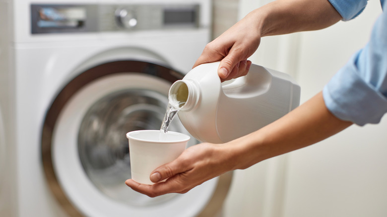 hands pouring bleach for laundry