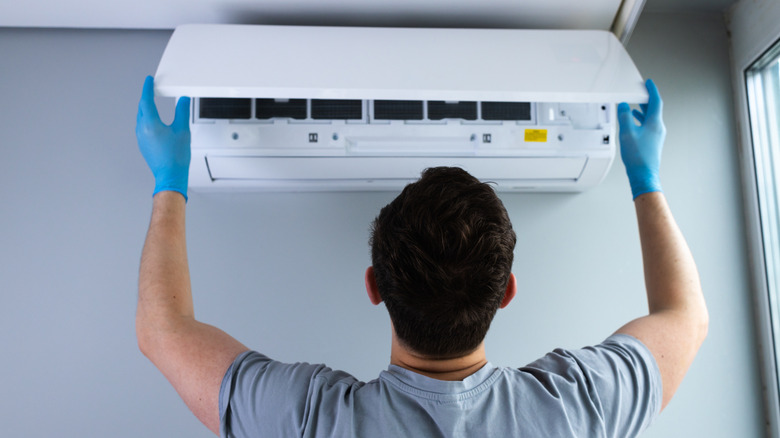 Technician installing a wall-mounted air conditioning unit