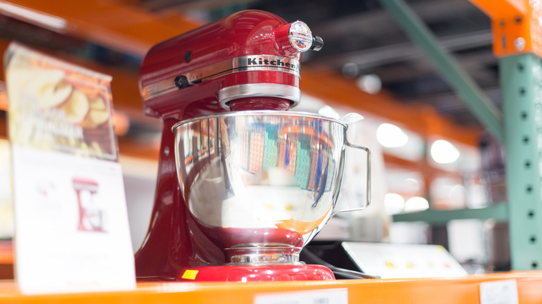 A red stand mixer on store shelf