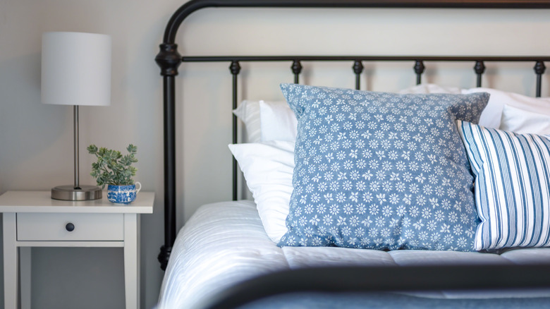 Blue and white bedding with iron bedframe
