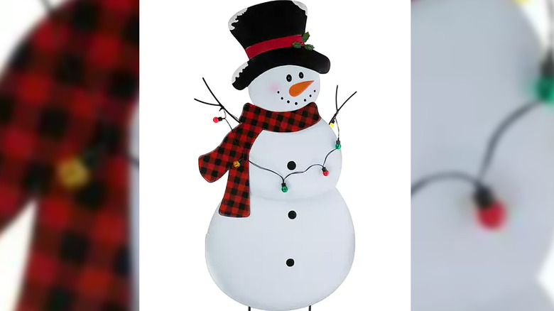 Garden stake decoration of a snowman with red scarf and string of lights