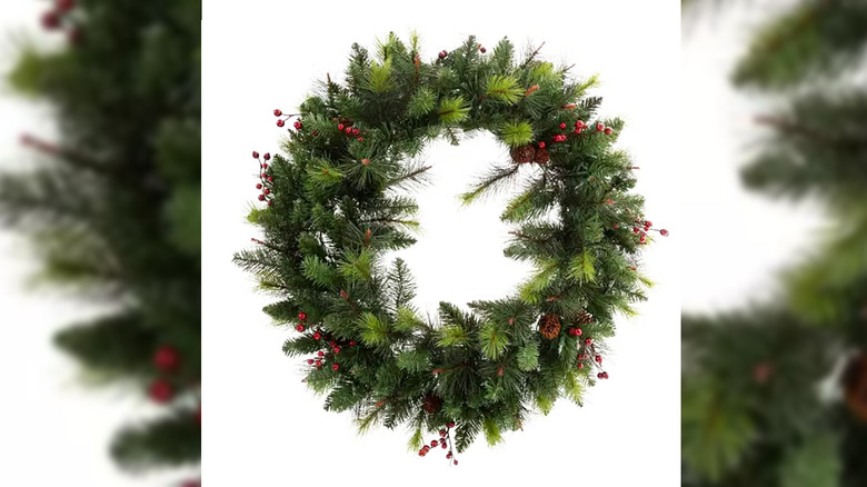 wreath with pinecones, berries, and lights on a white background