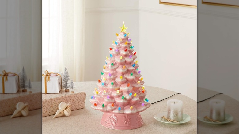 pink ceramic Christmas tree with light bulbs on a table with gifts