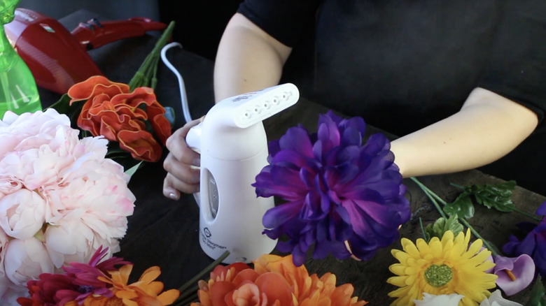 person steaming fake flowers