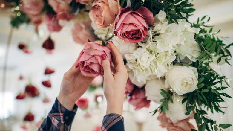 hands adjusting faux flower