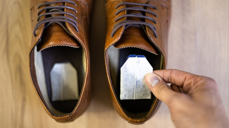 A person putting tea bags in their shoes