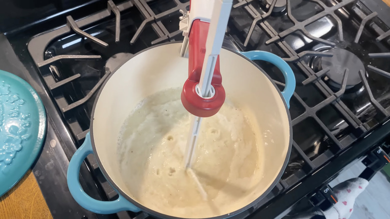 automatic pot stirrer mixing food in an enamel pot on stovetop