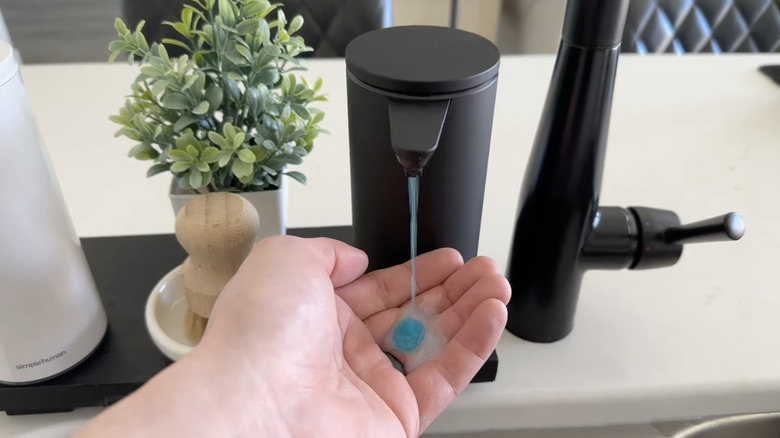 hand beneath automatic dispenser, dispensing soap