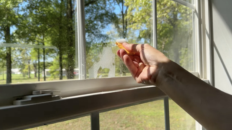 hand scraping window with razor