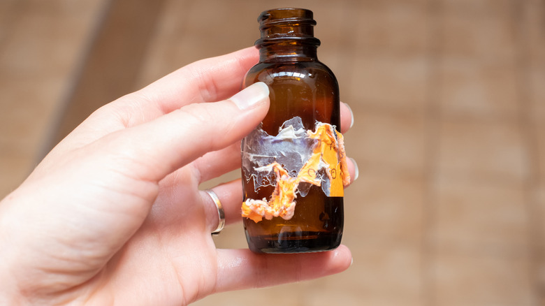 hand holding small glass jar with stuck-on label