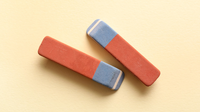 two rubber erasers on a yellow surface