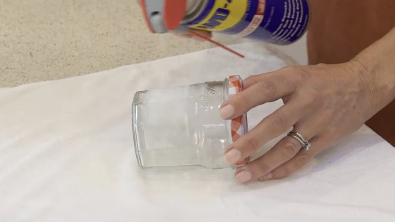 spraying WD-40 on jar