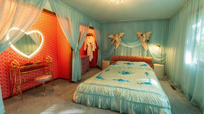 Room with light blue, shear curtains draped skillfully over the windows and walls.