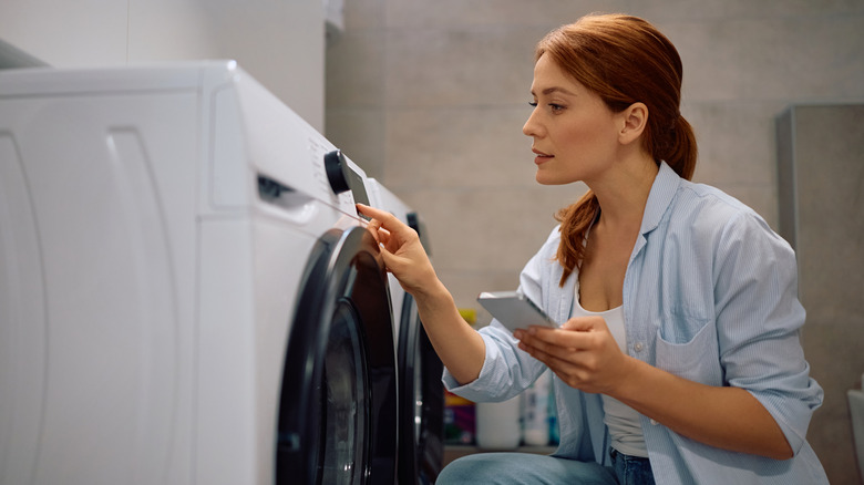 person choosing washing machine setting