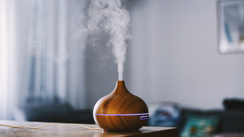 An oil diffuser on a table with visible mist