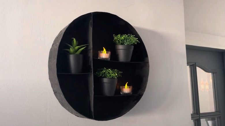 DIY Black circular cardboard shelf with artificial plants and tealight candles