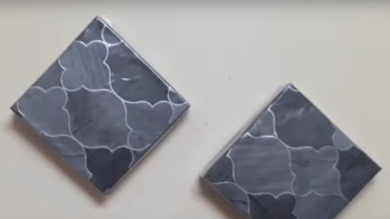 Gray-toned geometric wall art made of cardboard pizza lids and bottoms