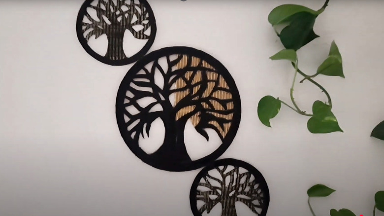Upcycled Tree of Life cardboard wall decor beside hanging pothos plant