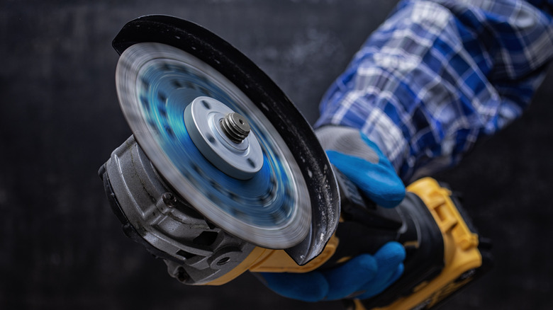 person holding angle grinder