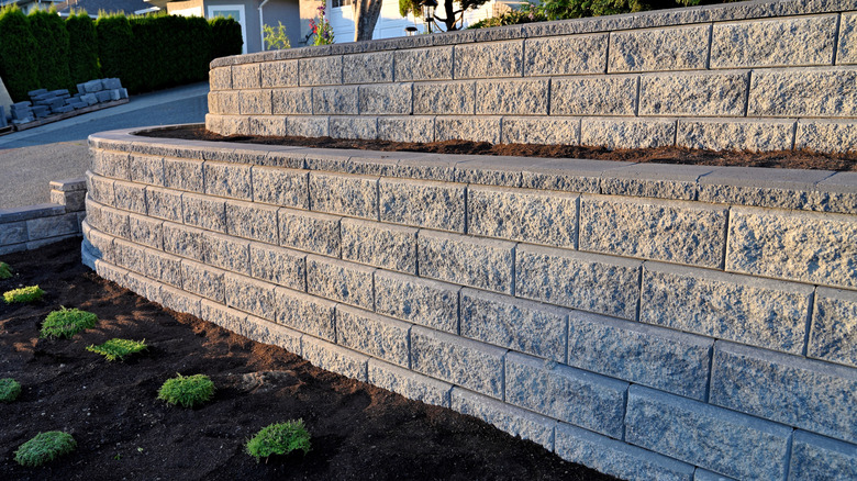 a concrete retaining wall in a sloped front yard
