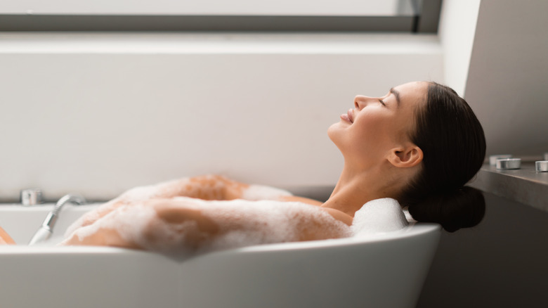 Woman relaxing in her resort-inspired bathroom