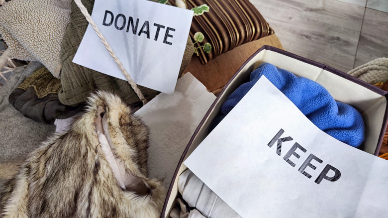 Winter clothing and accessories in donate and keep piles and boxes.