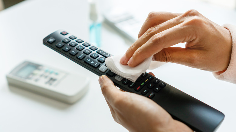 Someone cleaning TV remote
