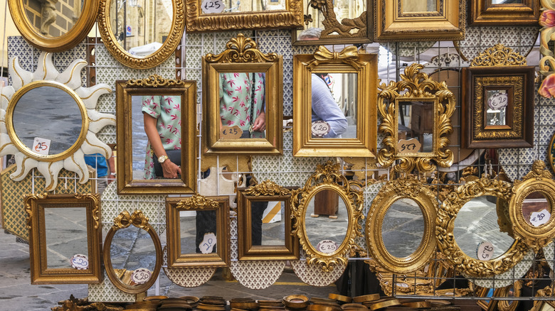 Mirrors on the shelf of a flea market in Italy.