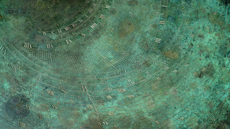 surface of a metal sundial that is green due to verdigris