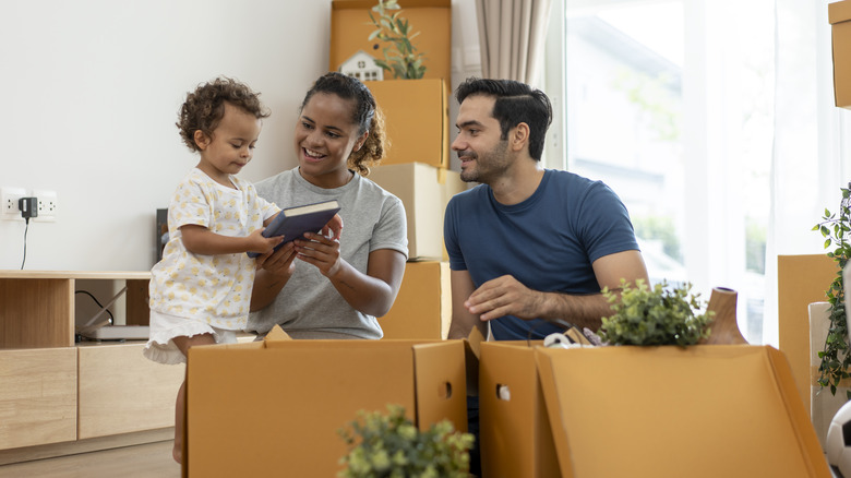 Parents with baby unpacking boxes