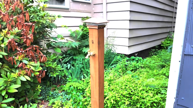 A wooden post with spigot attached and solar light on top