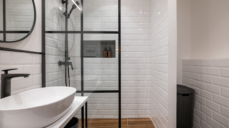 Bathroom with bright white subways tiles, white vessel sink, and black fixtures.
