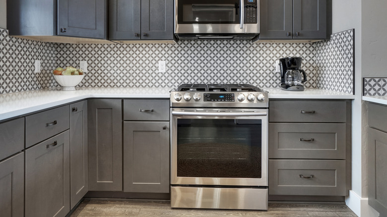 Kitchen with gray cabinets, wood floor, and stainless steel appliances