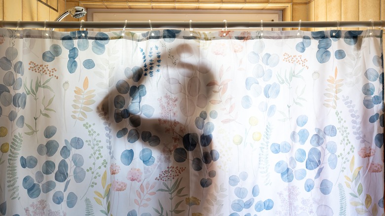 A man in a shower with a floral shower kitchen